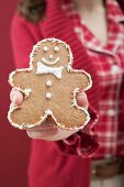 Woman holding decorated gingerbread man