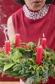 Woman blowing out candles on Advent wreath