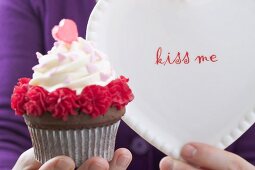 Woman holding Valentine's Day cupcake and plate