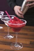 Strawberry Daiquiri in glass, bartender in background
