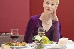 Gelangweilte Frau wartet auf den Partner beim Essen