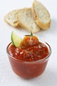 Tomato dip with wedge of lime, slices of white bread