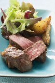 Beef fillet steak with potato wedges and salad