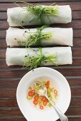 Drei Reispapierröllchen mit Chilisauce von oben (Asien)