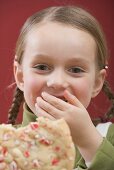 Small girl holding partly eaten Christmas biscuit