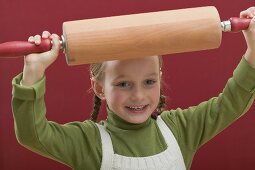 Small girl holding rolling pin