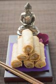 Spring rolls in front of Buddha statue