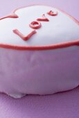 Herzförmige rosa Torte mit Aufschrift Love