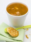 Tomatensuppe mit Einlage im Styroporbecher, daneben Cracker