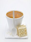 Tomatensuppe mit Einlage im Styroporbecher, daneben Cracker