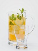 Iced tea with lemon slices and fresh mint in glass jug
