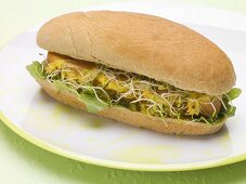 A hot dog with sprouts on a plate