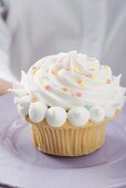 Hands holding cupcake on plate