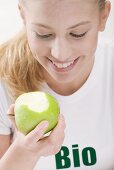 Frau isst grünen Bio-Apfel