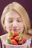 Frau hält Erdbeeren auf Teller