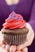 Hands holding chocolate cupcake