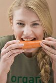 Woman biting a fresh carrot