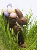 Chocolate Easter Bunny with sugar eggs in grass