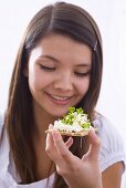 Girl holding crisp bread with cottage cheese and cress