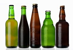 Various types of beer in bottles standing in a row