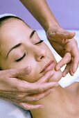 Young woman having cosmetic treatment (facial massage)