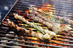 Belly pork kebabs with rosemary on barbecue