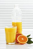 Orange juice in glass and plastic bottle