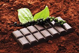 Chocolate bar and green peppercorns on cocoa