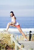 Young woman stretching leg