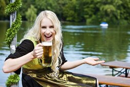 Germany, Bavaria, Munich, English Garden, Young woman holding beer stein