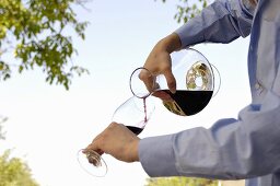 Man pouring red wine in glass