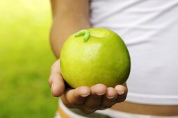 Person holding apple with caterpillar