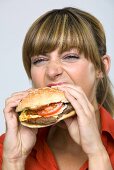 Junge Frau isst Hamburger