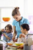 Mother and two children preparing meal in kitchen