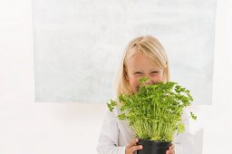 Girl holding a pot of parsley