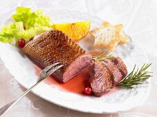 Duck breast with toast star and orange wedge