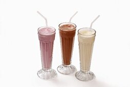 Three milkshakes in glasses with straws