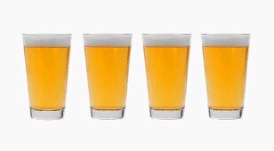 Four glasses of lager side by side