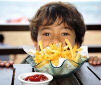 Boy at table with chips and ketchup