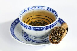 Rhabarberwurzel auf Holzschaufel mit Tee