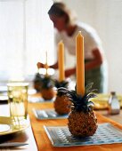Ananas auf Glasteller m. gelber Kerze dekoriert