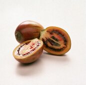 Eine ganze und eine halbierte Tamarillo