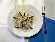 Rice salad with green asparagus and carrots on plate with fork on napkin
