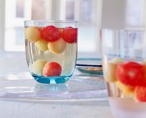Maibowle-Glas mit fruchtigem Inhalt, Kugeln von Melonen