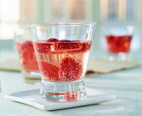 Maibowle-Glas mit fruchtigem Inhalt,aufgeschnittene Erdbeeren