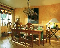 Pinienholztisch und antike spanische Stühle unterm Kerzenlüster