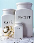 Drei Vorratsdosen aus weißer Keramik für Kaffee, Kekse und Thymian