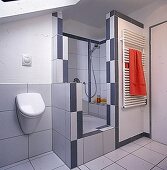 Neben der Dusche ist ein Urinal, orangefarb. Handtuch