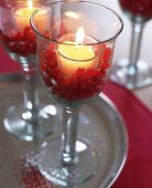 Teelicht in einem Glas,dekoriert mit roten Johannesbeeren. X.