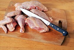 Hähnchen werden mit dem Messer zerteilt